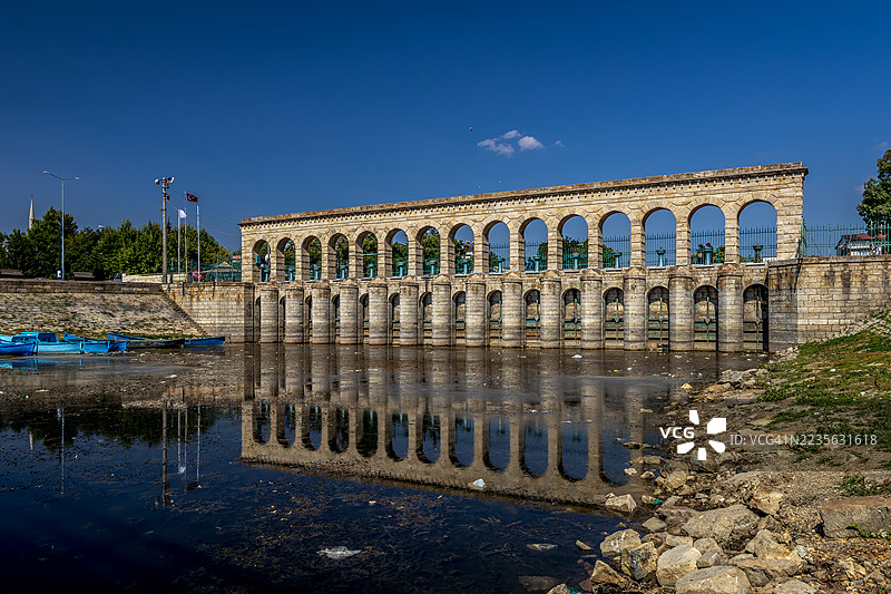 古罗马水渠在晴朗蓝天下的宁静水面上倒影图片素材