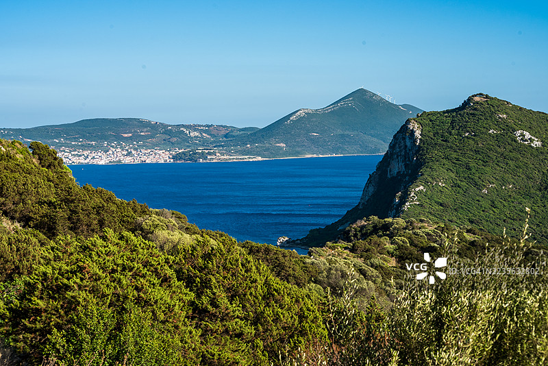 令人惊叹的海岸风景，生机勃勃的绿色山丘俯瞰着深蓝色的大海，天空晴朗，希腊，沃伊多科伊利亚图片素材