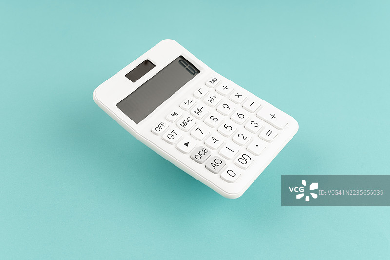 蓝色背景上的白色计算器，带有阴影。图片素材