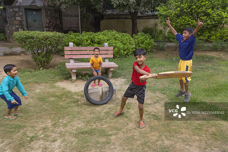男孩们在公园里打板球的肖像图片素材