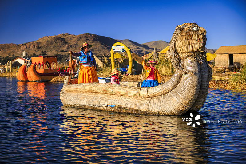 秘鲁年轻女性在的的喀喀湖乌罗斯浮岛之间航行图片素材