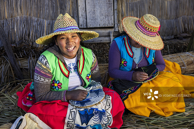 秘鲁乌罗斯浮岛上的年轻女性出售纪念品，蒂蒂卡卡湖，秘鲁图片素材