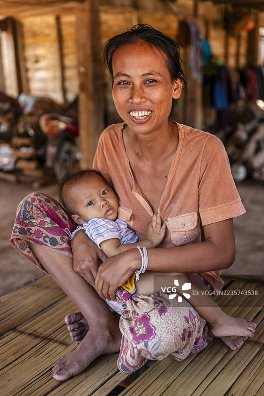 老挝北部村庄里年轻的妈妈抱着她的宝宝图片素材