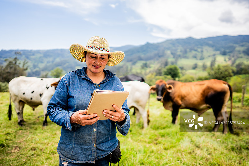一位农妇在哥伦比亚昆迪纳马卡省的农场上使用平板电脑图片素材