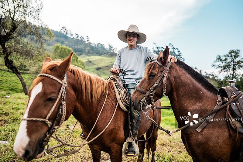 哥伦比亚昆迪纳马卡省田野里骑马的少年肖像图片素材