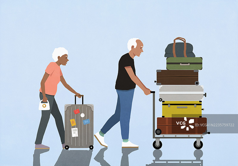 活跃的老年夫妇在旅行，推着装有行李和轮式行李的手推车图片素材