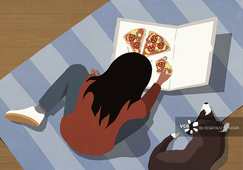 高角度视图的女孩在地板上吃披萨，旁边有宠物狗。图片素材
