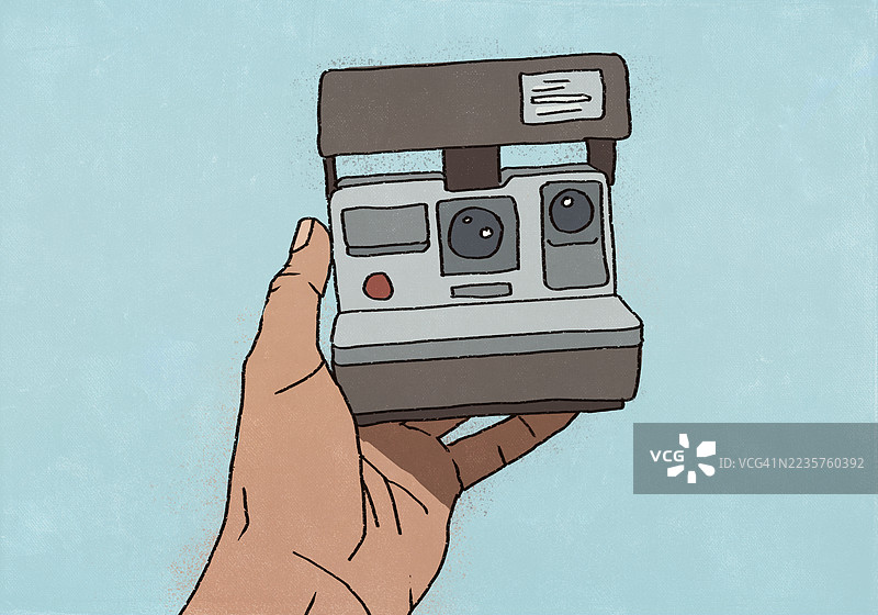 手持宝丽来相机自拍，背景为蓝色图片素材