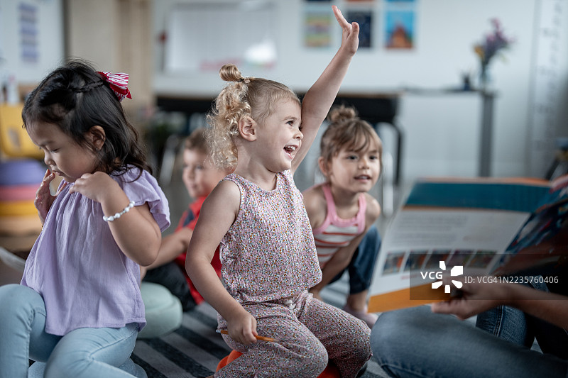 多元化的学前儿童在课堂活动中举手参与图片素材