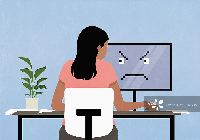 女人在电脑前工作，屏幕上显示愤怒的面孔图片素材
