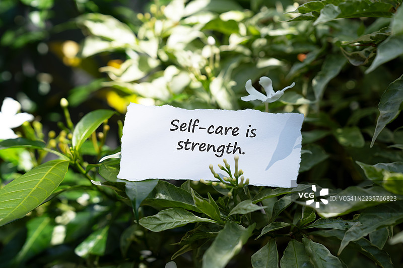 撕裂的纸张上写着励志名言：自我关怀就是力量图片素材
