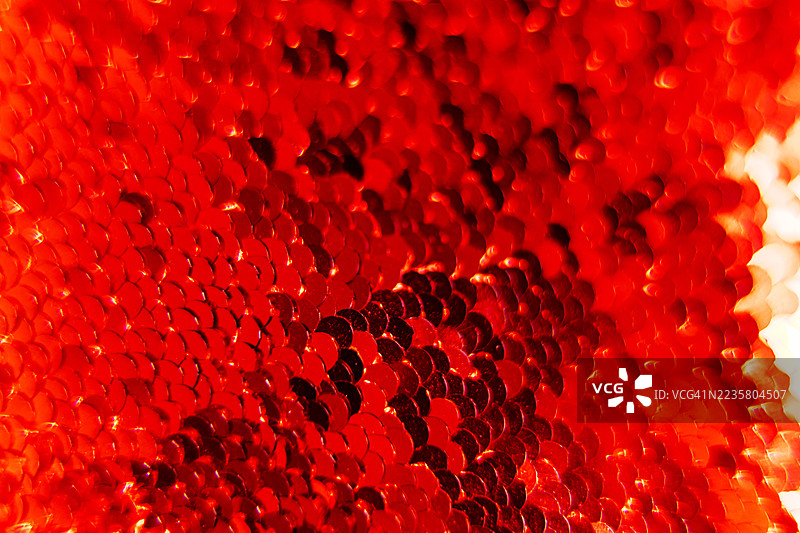 抽象的鲜艳红色亮片背景，带有闪烁和纹理高光图片素材