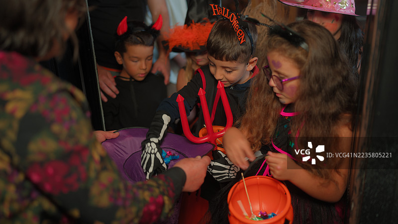 一群孩子朋友在夜晚收集万圣节糖果图片素材