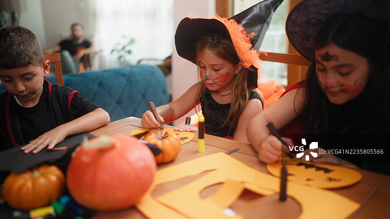小朋友们在家里的万圣节聚会上制作万圣节装饰品图片素材
