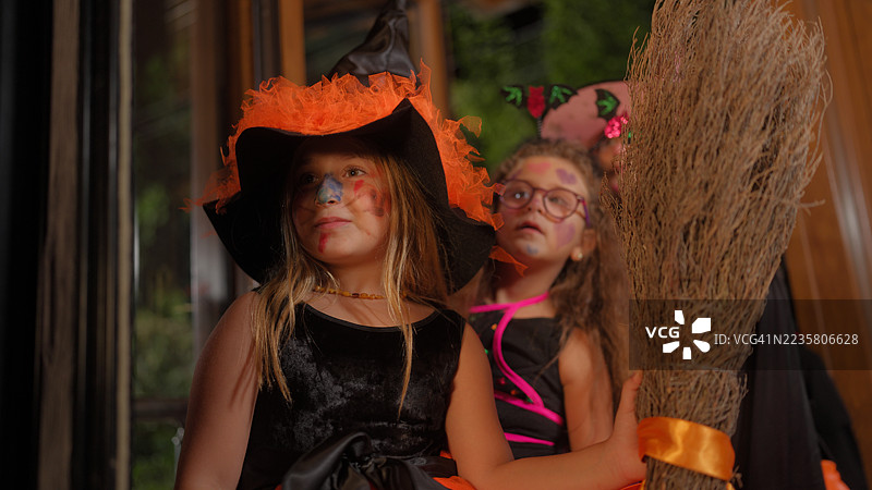 一群孩子和父母在夜晚一起拜访邻居家讨要万圣节糖果图片素材