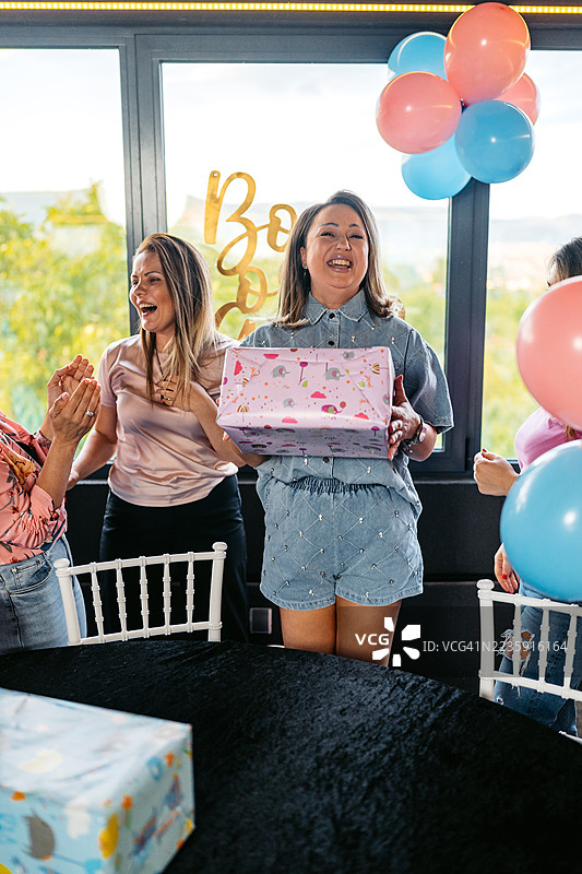一群中年女性在室内为她们的女性朋友举办性别揭晓派对图片素材