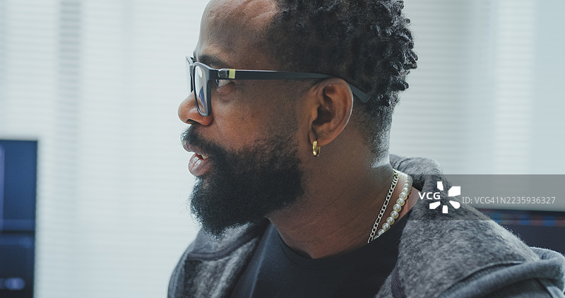 黑人和西班牙裔男性工程师程序员在科技办公室合作，近距离观察机器人手原型，佩戴虚拟现实头盔测试控制机器人手臂电路。软件开发者，人工智能。图片素材