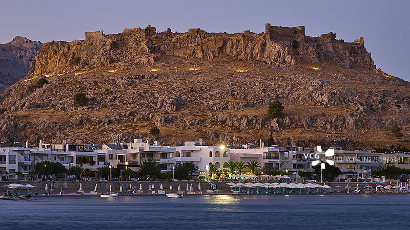 费拉克洛斯城堡,黄昏时古老城堡,下方城镇灯火通明,海面平静,海湾,哈拉克,哈拉克,罗德岛东海岸,罗德岛,佐泽卡尼萨群岛,希腊岛屿,希腊图片素材