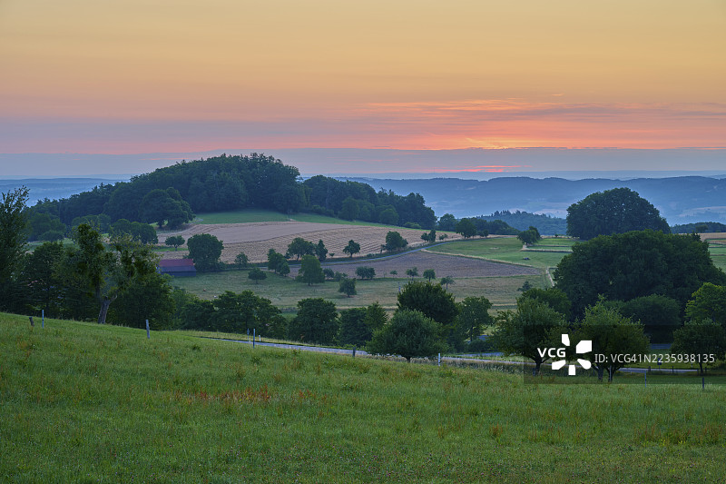日出时的风景，田野和树木在日落时分，德国黑森州奥登瓦尔德的劳登瑙，赖希尔斯海姆图片素材