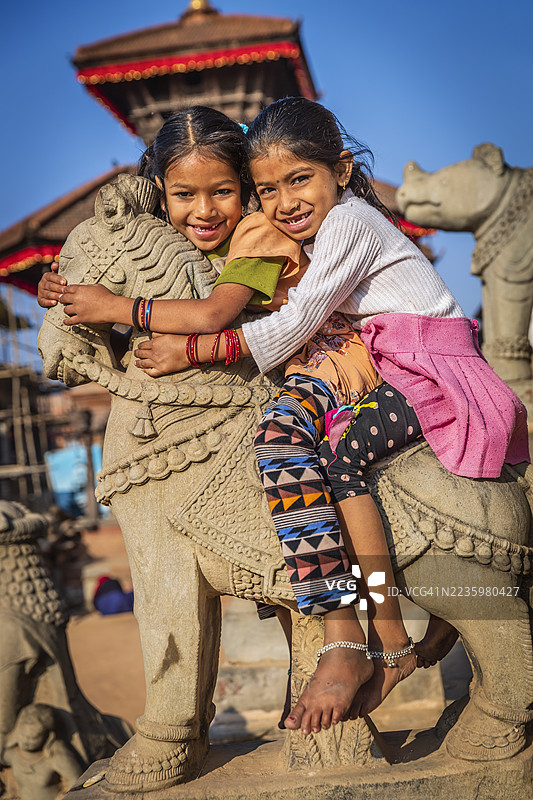 小尼泊尔女孩在巴克塔普尔的印度教寺庙玩得很开心图片素材