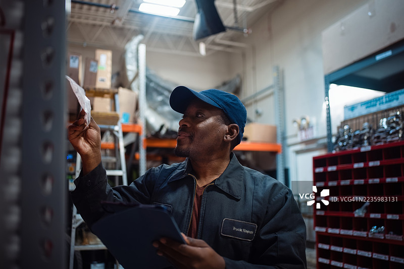 仓库工人在物流环境中用夹板整理库存图片素材