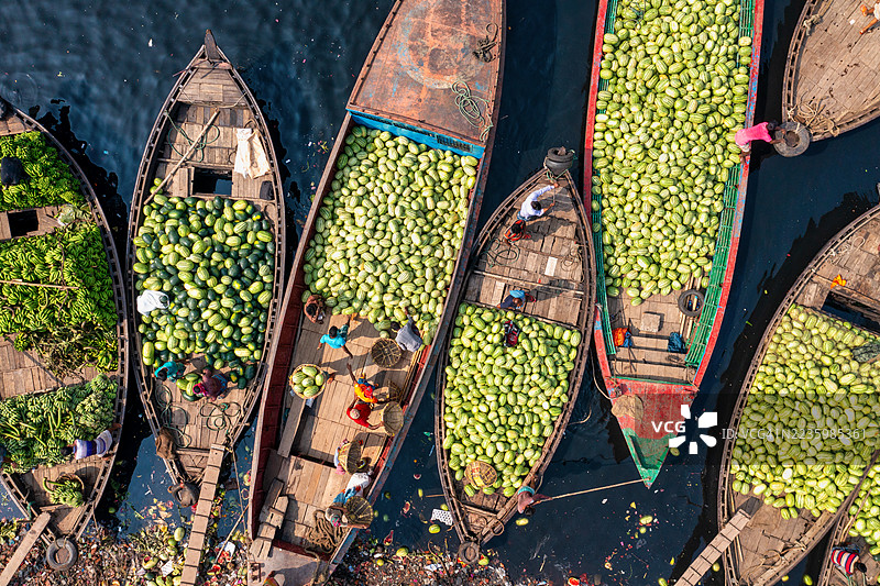 高角度视图展示了一个繁忙的水上市场，船只上满载着西瓜和香蕉，展现了水上生意的活力和日常生活。图片素材