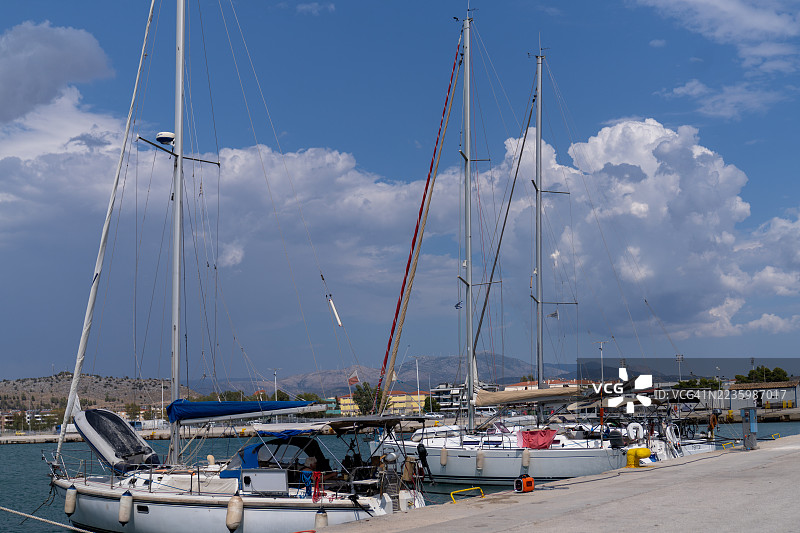 低角度视图的帆船停靠在港口，背景是蓝天和云朵，展示了海洋休闲和旅行。图片素材