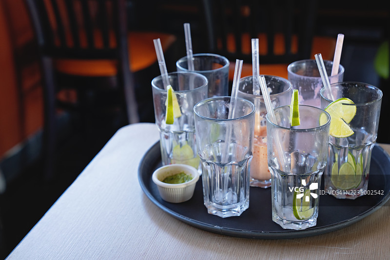 餐厅里装有空玻璃杯和剩菜的托盘图片素材