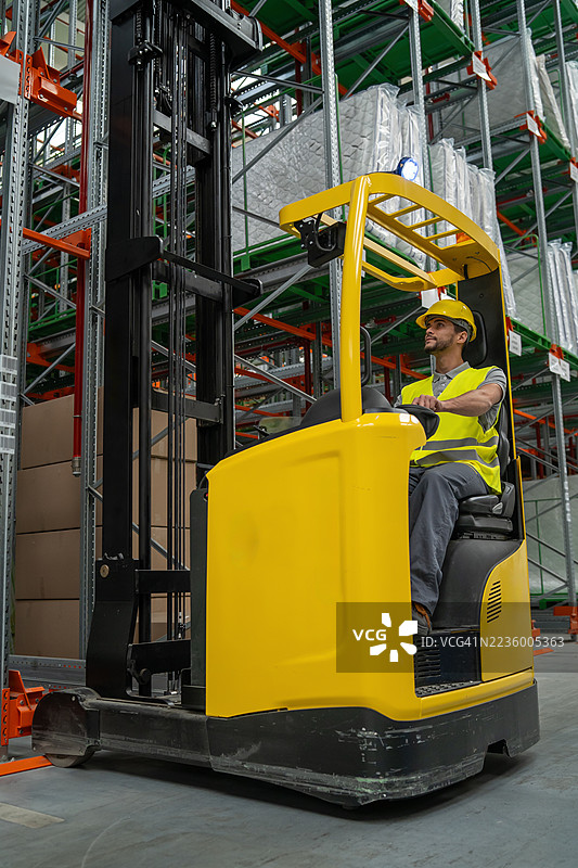 男性叉车操作员在仓库内灵活驾驶图片素材