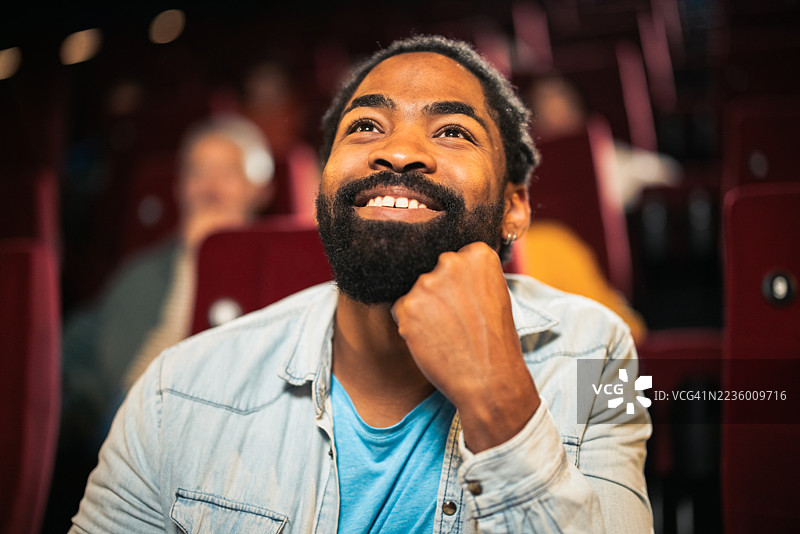 年轻男子在电影院享受电影图片素材
