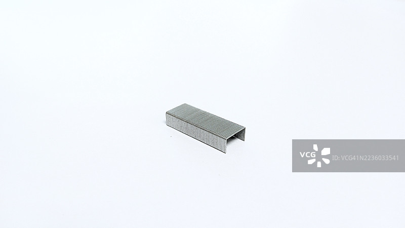 白色背景上的金属订书钉特写，象征着办公用品、文具和文件整理图片素材