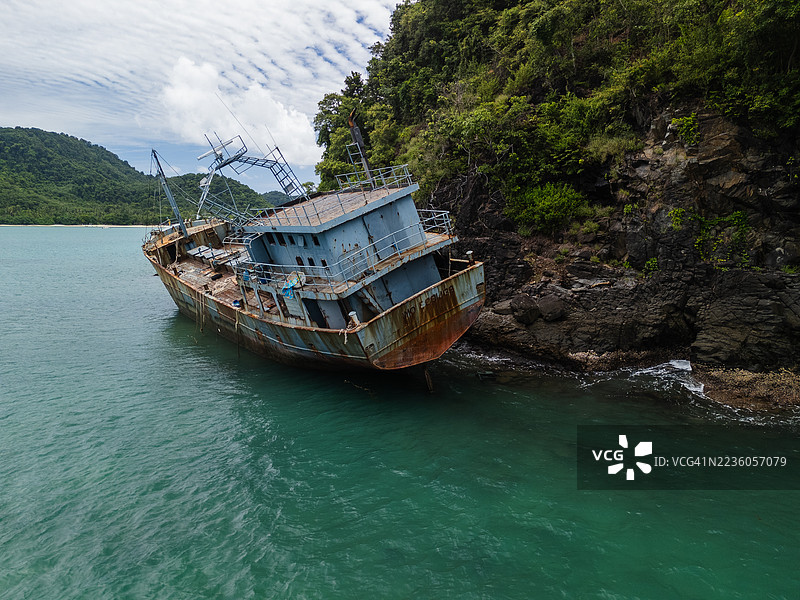 废弃的生锈船只在崎岖的海岸线上图片素材