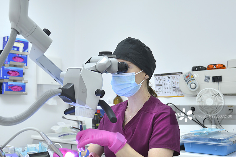 牙医使用显微镜进行工作。图片素材