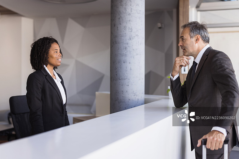 商人向酒店接待员询问信息图片素材