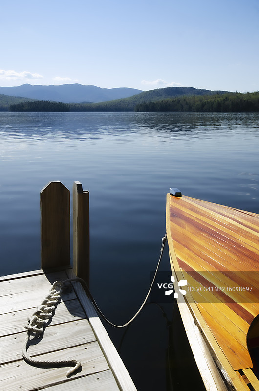 停靠在湖泊平静水面的古董木船图片素材