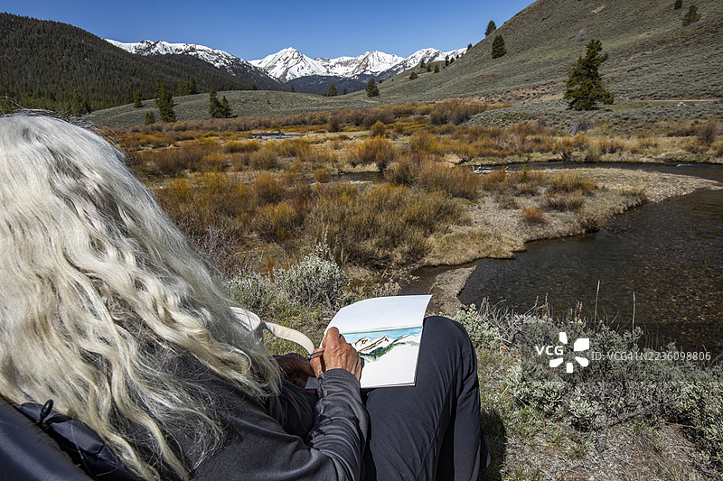 女性背影正在画北叉大失落河的画作图片素材