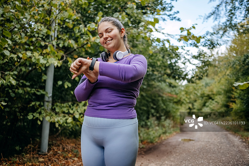 年轻女性穿着运动服在自然环境中跑步，过着健康的生活方式图片素材