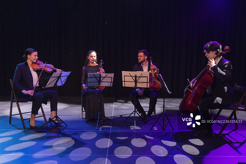 优雅的弦乐四重奏在五光十色的灯光下现场演出图片素材