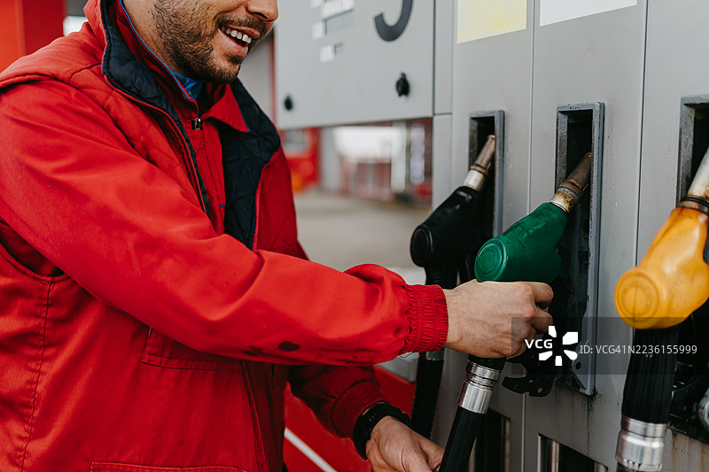 男子在加油站给汽车加油图片素材
