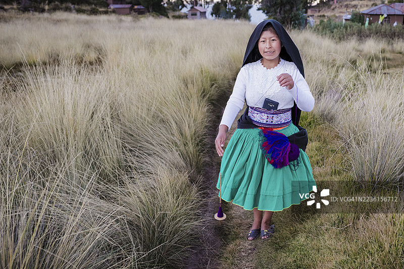 年轻女性在秘鲁的的的喀喀湖塔基尔岛上手工纺羊毛图片素材