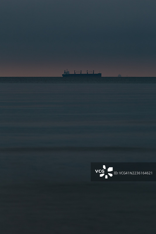 日落时分，海面与戏剧性的天空相映成趣，远处有船只，德国宾茨，普罗拉。图片素材