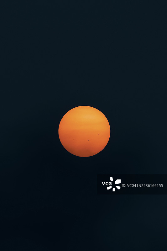 深蓝背景上的简约橙色太阳图片素材