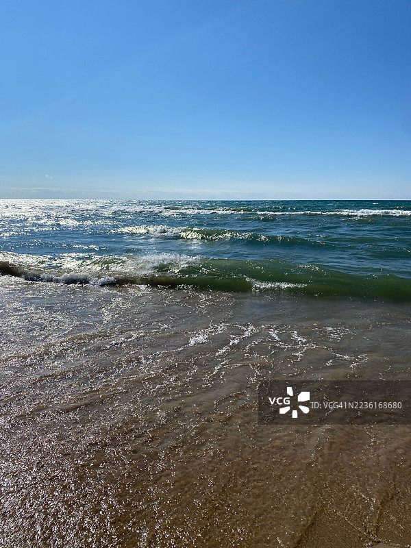 阳光明媚的日子里，清澈蓝天下，海浪拍打着沙滩的美丽景色，科维特，美国图片素材