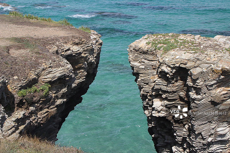 高角度视图的戏剧性海岸悬崖和碧蓝的海洋水域图片素材