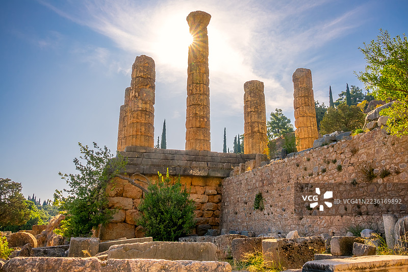 希腊古希腊神庙遗址低角度视图，高耸的柱子在灿烂的蓝天和阳光下，希腊图片素材