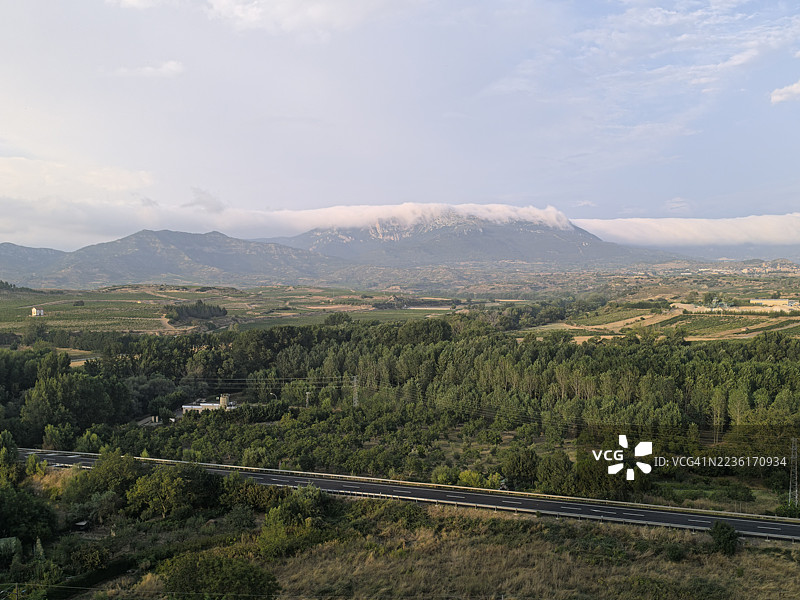 西班牙哈罗的郁郁葱葱的山谷全景，山间公路，云雾缭绕的天空图片素材