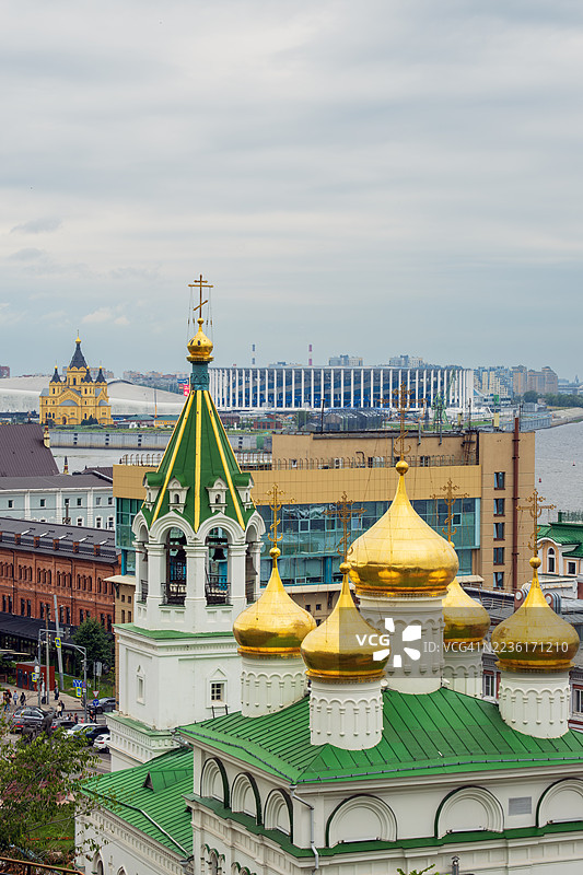 俄罗斯下诺夫哥罗德，阴云密布的天空下，俯瞰金色圆顶的东正教古老教堂与现代城市天际线图片素材
