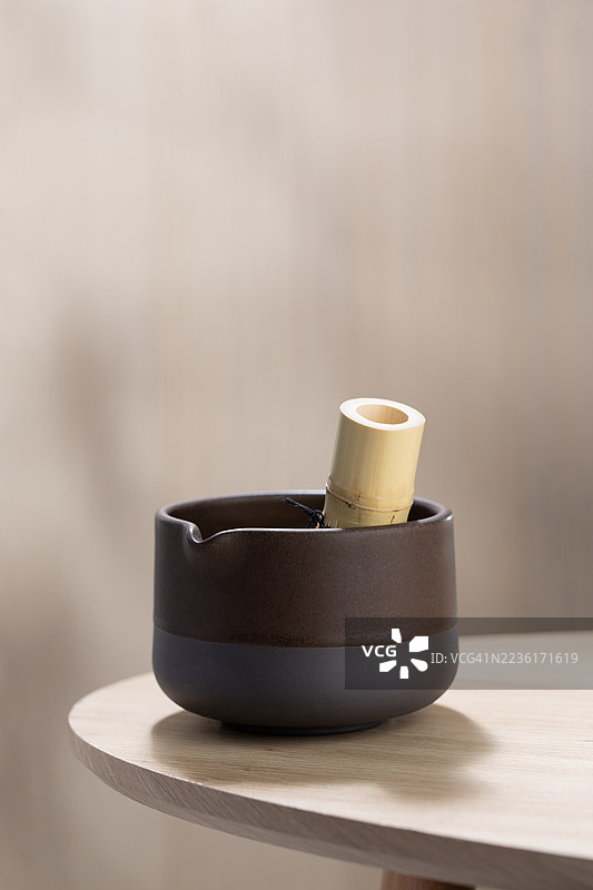 特写的陶瓷抹茶碗和竹制茶 whisk 放在木桌上，准备进行茶道仪式图片素材