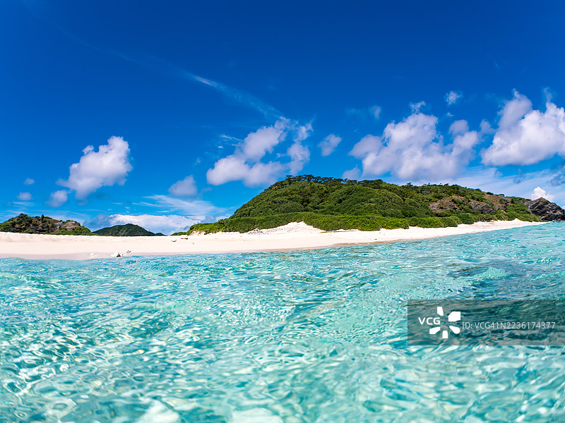 可以看到阳伞、船只，甚至是独特于冲绳的双体船Sabani。拍摄了美丽的白色沙滩的一半。还有一群热带鱼。美丽的珊瑚礁和游泳的人们。外岛、座间味岛、慶良間群岛。图片素材