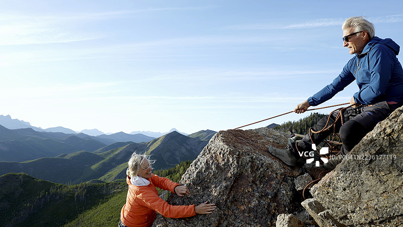 成熟夫妇在山顶攀登图片素材